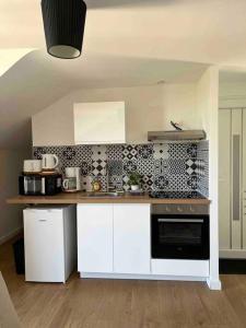 een keuken met witte kasten en een zwarte oven bij Appartement 40m2 centre de Vichy in Vichy