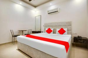 1 dormitorio con 1 cama grande con almohadas rojas en OYO Flagship Av Continental, en Zirakpur