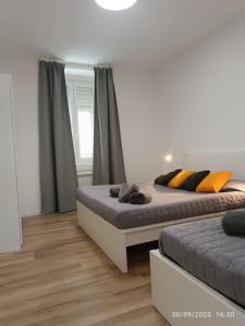 2 Betten in einem Schlafzimmer mit Holzböden in der Unterkunft Casa vacanze Mami in Triest