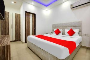 a bedroom with a large bed with red pillows at OYO Flagship Av Continental in Zirakpur