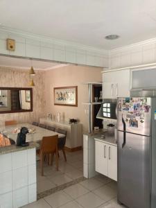 uma cozinha com um frigorífico de aço inoxidável e uma mesa em Casa em Aparecida em Aparecida