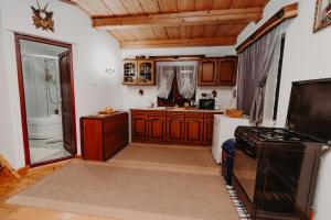 een keuken met houten kasten, een wastafel en een fornuis bij Pleta View in Vatra Dornei