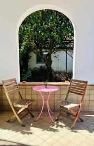 2 chaises, une table rose, une table et des chaises dans l'établissement GrannyHome, à SantʼArpino