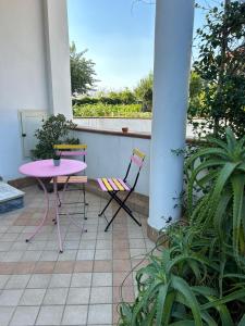 une table et des chaises roses assises sur un balcon dans l'établissement GrannyHome, à SantʼArpino
