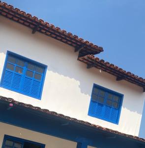 dos ventanas azules en el lateral de un edificio en Pousada JK, en Pirenópolis