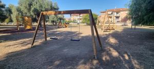 um parque infantil vazio com um baloiço num parque em La Casa di Trilly em Cerveteri