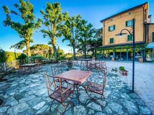 un grupo de mesas y sillas frente a un edificio en I Capricci Di Merion - Resort & Spa, en Tuoro sul Trasimeno