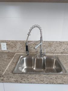 a kitchen sink with a faucet on a counter at COBERTURA no CENTRO BOMBINHAS in Bombinhas