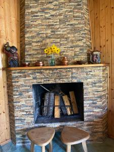 a stone fireplace with two stools in front of it at House of greenery in Kutaisi