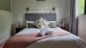 a bed with a pink blanket and a stuffed animal on it at Selah Holiday Cabin II in Lake Marina +28 photos