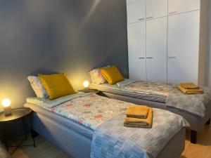 two beds in a room with yellow pillows on them at Arctic Escape in Rovaniemi
