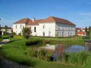 una gran casa blanca con un estanque frente a ella en Maison entière 5 mn Roissy CDG/15 mn Parc Astérix en Le Mesnil-Amelot
