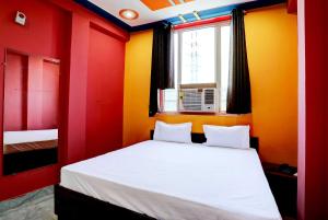 a bedroom with red and yellow walls and a bed at OYO Hotel Sk Inn in Ghaziabad