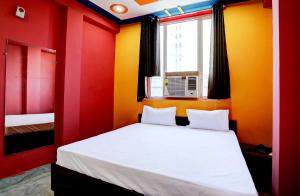 a bedroom with red and yellow walls and a bed at OYO Hotel Sk Inn in Ghaziabad