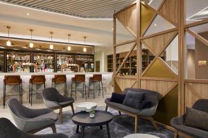 a bar in a restaurant with chairs and tables at Courtyard by Marriott London City Airport in London