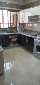 a kitchen with a sink and a washing machine at Dar fatima in Temara