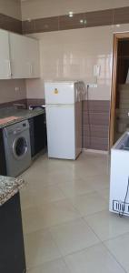 a kitchen with a refrigerator and a washing machine at Dar fatima in Temara