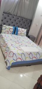 a bed with a colorful comforter and a pillow at Dar fatima in Temara