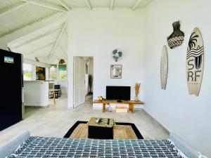 a living room with a table and a tv on a wall at Appart au Helleux in Sainte-Anne