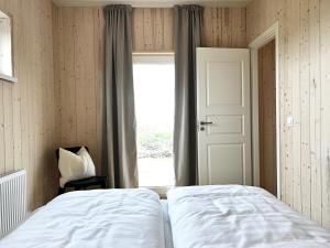 Schlafzimmer mit einem Bett und einem Fenster in der Unterkunft REY Stays - House in Höfn