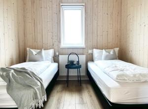 two beds in a room with a window at REY Stays - House in Höfn