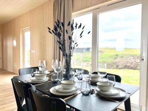 a dining room table with chairs and a large window at REY Stays - House in Höfn