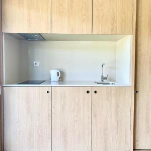 a kitchen with a sink and wooden cabinets at Quinta de Santa Ana, em Vizela in Infias