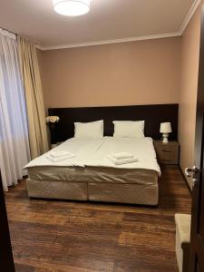 una camera da letto con un letto con lenzuola bianche e cuscini bianchi di Guest House EGO a Bratsigovo