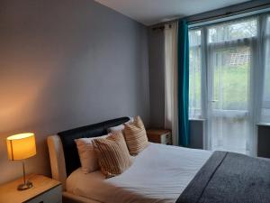 a bedroom with a bed and a window at Ferndale Place - Huku Kwetu Luton- Spacious 4 Bedroom Suitable & Affordable Group Accommodation - Business Travellers in Luton
