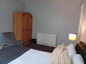 Tempat tidur dalam kamar di Ferndale Place - Huku Kwetu Luton- Spacious 4 Bedroom Suitable & Affordable Group Accommodation - Business Travellers