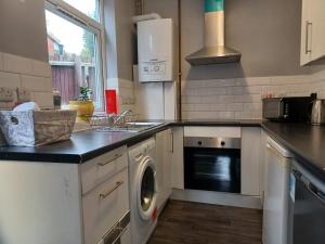 a kitchen with a washing machine and a sink at Ferndale Place - Huku Kwetu Luton- Spacious 4 Bedroom Suitable & Affordable Group Accommodation - Business Travellers in Luton