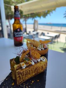 uma sanduíche numa mesa ao lado de uma garrafa de cerveja em Alboran hotel em Carboneras