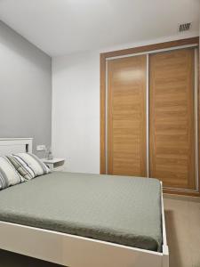 a bedroom with a bed and a wooden closet at Apartments Zarate in Granada