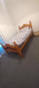 1 cama con marco de madera en una habitación en The Annex, en Roundwood