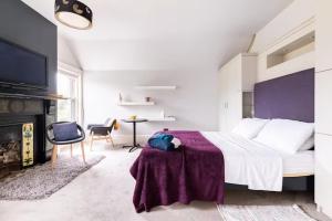 ein Schlafzimmer mit einem großen Bett mit einer lila Decke in der Unterkunft Yeovil in Rathgar