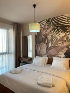 1 dormitorio con 1 cama grande y un gran mural de hojas en Erida’s Apartment, en Tirana
