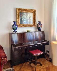 ein Klavier mit Vasen darüber mit einem Stuhl in der Unterkunft Mancini 1 - Gran Madre in Turin