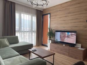 sala de estar con sofá y TV de pantalla plana en Erida’s Apartment, en Tirana