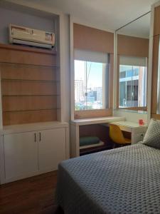 een slaapkamer met een bed, een bureau en een raam bij Sweet Copacabana in Rio de Janeiro