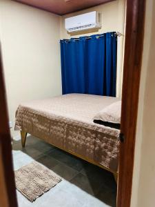 um pequeno quarto com uma cama e uma cortina azul em Casa Amanda em Talamanca