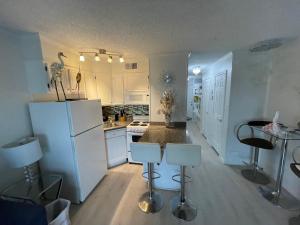 a kitchen with white cabinets and a white refrigerator at Casa Del Mar Sun Diamond One Bedroom Retreat - Galveston in Galveston