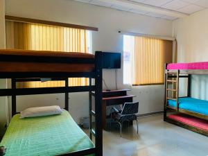 Zimmer mit 2 Etagenbetten und einem TV in der Unterkunft Hostal Zaguán Caldense in Manizales