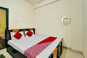 1 dormitorio con 1 cama con almohadas rojas en OYO Flagship Residence Inn Guest House, en Patna