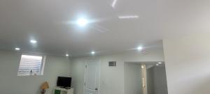 biały pokój z oświetleniem na suficie w obiekcie Comfy basement near KW airport w mieście Kitchener
