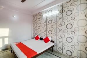 グルガオンにあるOYO Flagship Corporate Houseのベッドルーム1室(赤い枕のベッド1台付)