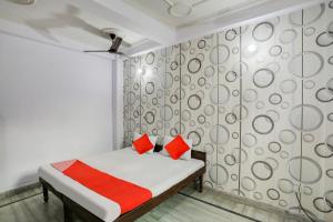 um quarto com uma cama com almofadas vermelhas em OYO Flagship Corporate House em Gurgaon
