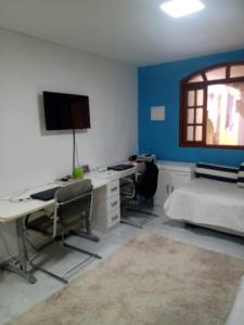 Cette chambre comprend un bureau, un lit et un ordinateur. dans l'établissement Casa de praia, à Saquarema