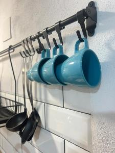 Une bande de casseroles et de poêles suspendues sur un mur dans l'établissement Estudio Interior Kala - Only Adults - Private Room, à Jerez de la Frontera