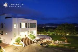a large white building with stairs in front of it at The South-Dawn in Hengchun