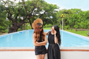 two women standing next to each other in front of a pool at The South-Dawn in Hengchun